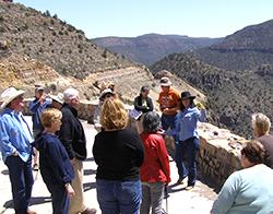 Tour Leader talking to tour guests in a barren, mountainous landscape